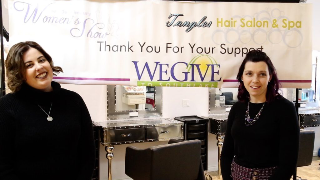 Two Tangles Employees under a thank you banner from women's show